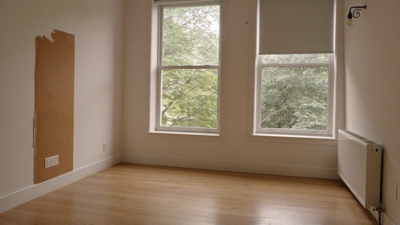 Montréal apartment living room with careless details: a crooked blind and an unpainted wall patch